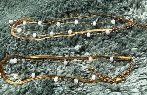 Customer's original and new Layered Snake Chain Gold Anklets resting on a soft textured surface.
