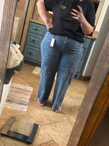 Reviewer wearing Judy Blue high-waist jeans with snakeskin print and wide legs in front of a mirror.