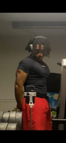 Reviewer's black SuperVillain Compression Tee, worn while flexing in a gym mirror.