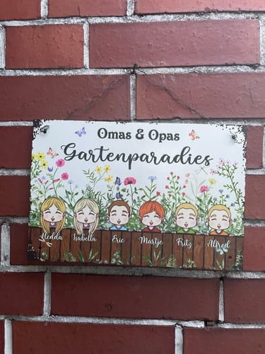 Kunden-Türschild Omas & Opas Gartenparadies mit farbenfrohen Blumen und illustrierten Charakteren an einer Ziegelwand.
