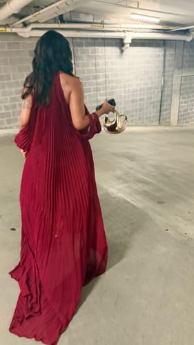 Reviewer in a wine-colored Chiffon Pleated Gown with a flowing, floor-length train, walking in a parking garage.