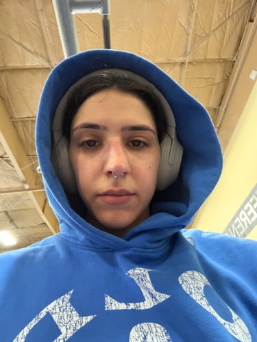 Reviewer wearing a cozy, blue Gold's Gym Classic Pullover hoodie with the hood up, showing a distressed graphic.