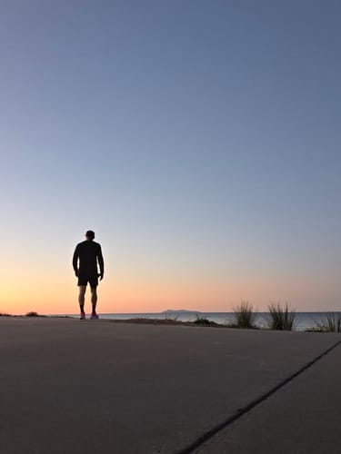 Reviewer standing on a pathway at sunset after a workout, fueled by UGLYFACE® CARB-DEX.