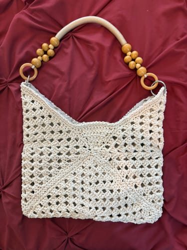 Reviewer's finished Sunny Holiday shoulder bag, displaying a beige crochet pattern with decorative beaded handles.