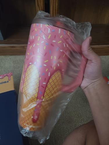 Reviewer's pink ice cream Mystery Thicc Buddy tumbler inside protective plastic packaging.