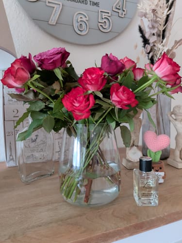 Kundenfoto des Parfums Kiage 286 neben einem großen Strauß roter Rosen in einer Glasvase.
