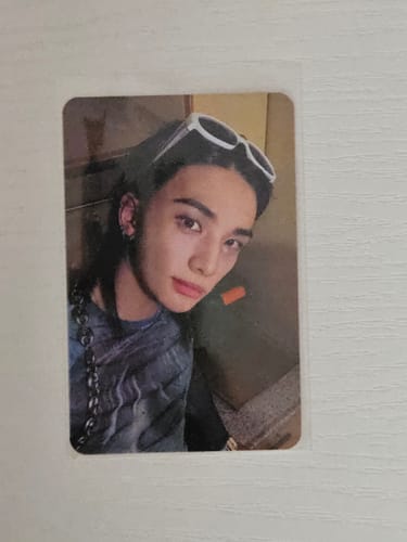 Customer's Stray Kids photocard featuring a person wearing dark sunglasses on top of their head and a chain strap.