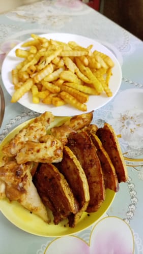 Customer's Novio StonePro air fryer results: a plate of golden fries and a plate of grilled chicken and meat slices.
