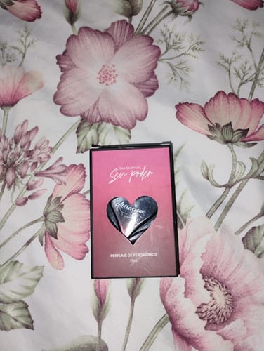 Customer's Attracione Sensual perfume box with a heart-shaped cutout on a floral patterned bed sheet.