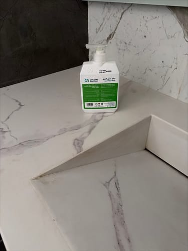 صورة المراجع لمنتج Best Clean Hand Wash بعبوة بيضاء موضوعة على حوض رخامي أنيق في الحمام.