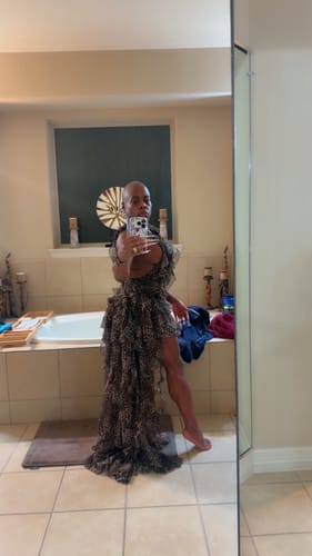 Reviewer's leopard print chiffon dress with layered ruffles and high-low hem in a bathroom mirror.