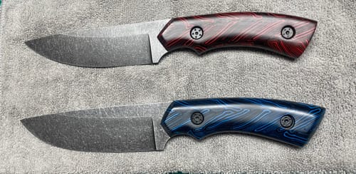 Customer's two finished knives with distinct red and blue handles, sharpened using 2 X 42 Inch Zirconia Sanding Belts.