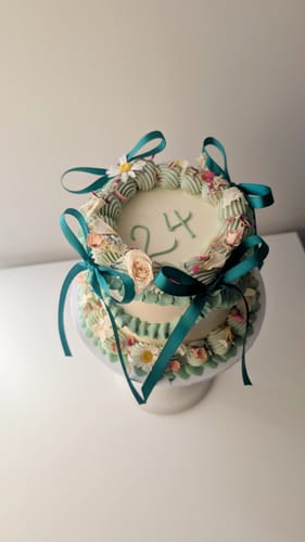 Customer's Ivory White Freeze Dried Edible Violas used to decorate a birthday cake with green ribbon.