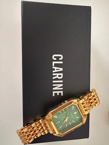 Customer's gold Claire De Mains watch with green dial, displayed on the brand box.