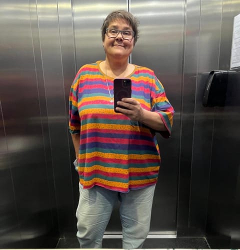 Customer's cotton colorblock stripe blouse worn with light pants in a mirror selfie