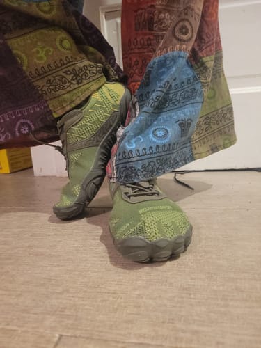 Customer's green Free Ⅰ barefoot shoes being worn with colorful patterned pants.