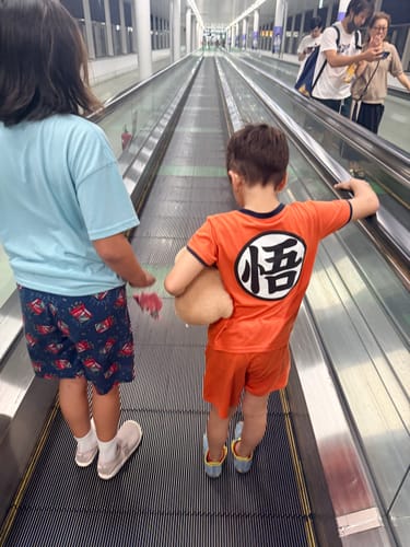 Customer's Kid's Agile IV Barefoot Shoes being worn by a child walking on an airport moving walkway.