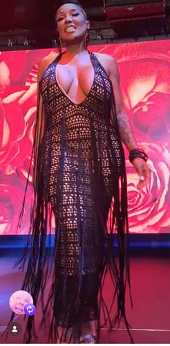 Reviewer wearing a black crochet maxi dress with a halter neckline and fringe detailing.