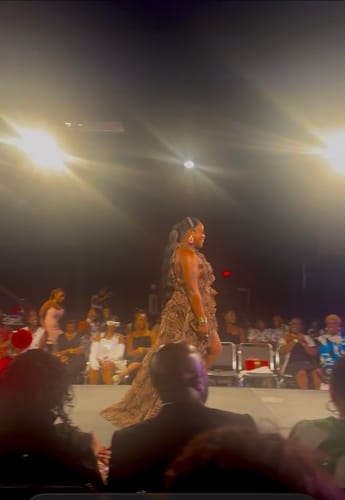 Reviewer wearing the Chiffon Print Asymmetric Ruffle Dress while walking on a fashion show runway.