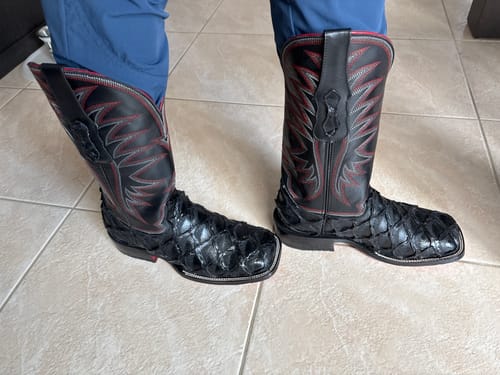 Customer's black Pirarucu leather boots with square toes, worn on feet over tile flooring.