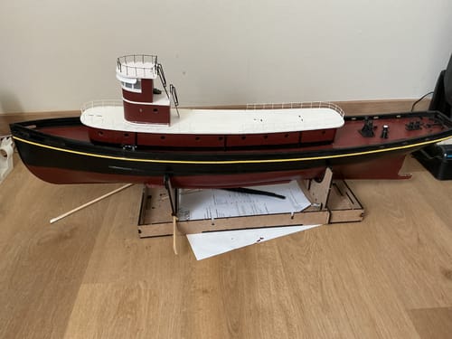 Reviewer's Maqueta del Remolcador Hércules, un modelo a escala del barco en construcción, colocado sobre un soporte.