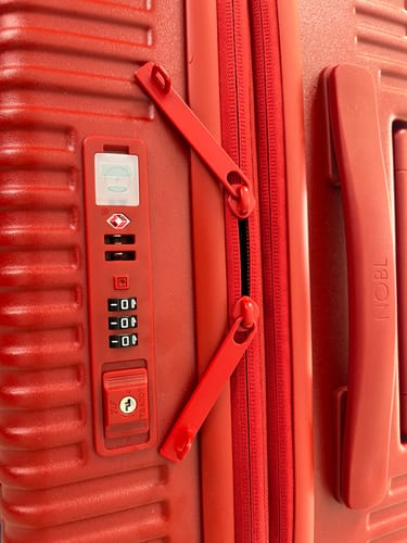 Customer's red Carry-On: All-in-One Expandable, close-up view of the zipper closure and TSA combination lock.