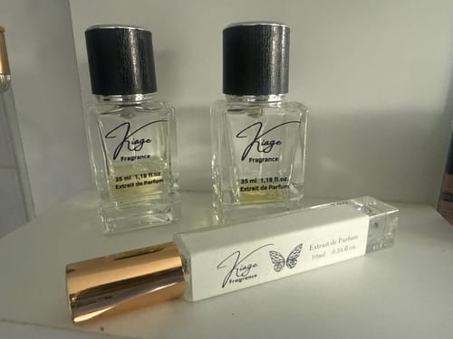Kunden-Review des 2er Duft Bundles mit zwei transparenten Glasflakons und einem kleineren Zerstäuber auf weißer Fläche.