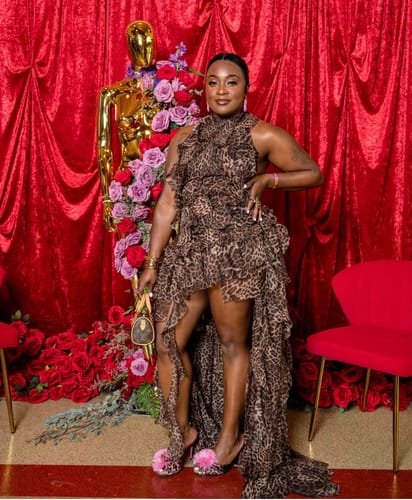 Customer's Chiffon Print Asymmetric Ruffle Dress featuring a leopard print and layered ruffles, worn in front of roses.
