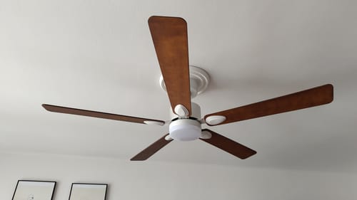 Reviewer's Mistral teinté Chêne ventilateur de plafond avec cinq pales en bois chêne installé au plafond.