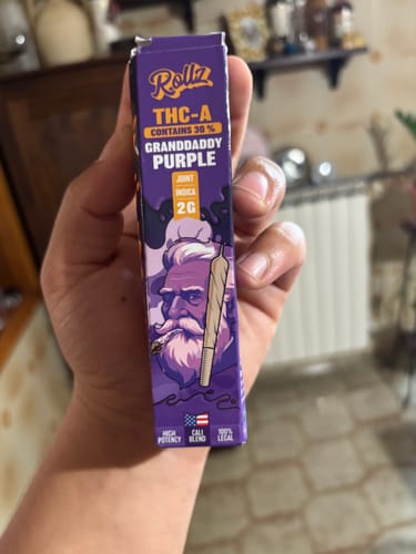 Customer's hand holding a purple Cali Blend THC-A Pre-Roll box featuring Granddaddy Purple branding.