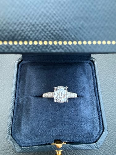 Customer's Semi Mount ring with a sparkling center stone, resting inside a blue velvet box.