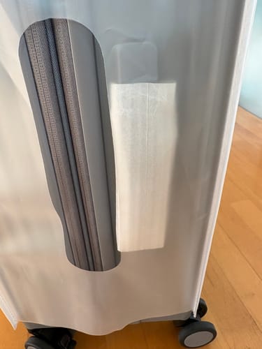 Customer's Luggage Cover on a suitcase, showing misalignment of the handle opening.