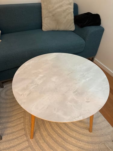 Customer's Marmor romeo hvit matt kontaktplast påført et rundt bord i en stue.
