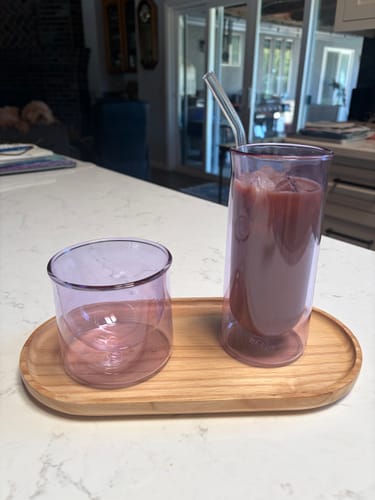 Customer's FLUR Latte Lovers Set glasses in light purple color on a wooden tray with an iced drink.