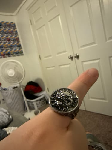 Customer's silver Sunny Ring on a finger, featuring an unhinged face design with mouth open.
