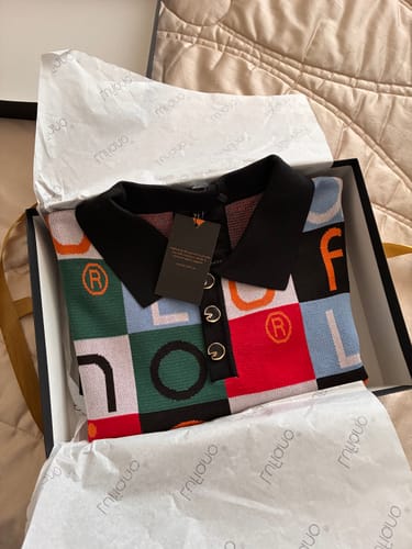 Customer's LFN007 knit top with colorful block patterns and black collar, presented in a gift box.