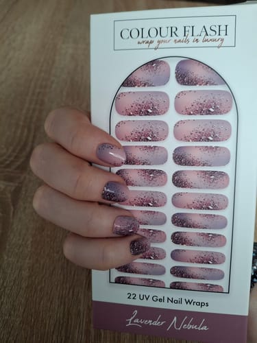 Kundenhand hält die Verpackung der Lavender Nebula UV Nagelfolien mit dem abgebildeten Farbverlauf.