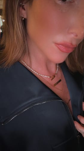 Reviewer's Molten T-Bar Necklace worn with a pearl necklace, close-up.