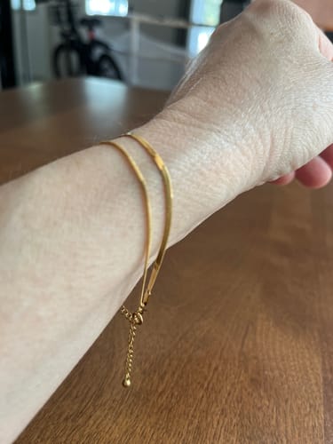 Customer's gold-toned Double Snake Chain Layered Bracelet worn on wrist, showing delicate chains and adjustable clasp