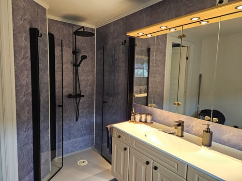 Customer's Firenze selvklebende fliser installed on a bathroom wall next to a shower.