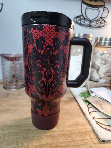 Customer's Thicc Buddy 50oz tumbler in red and black lace pattern standing on a wooden surface.