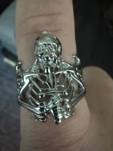 Customer's silver Ring of Suffering worn on a finger, featuring an intricate skeleton design.