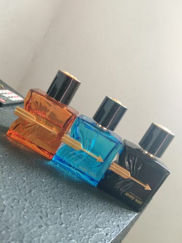 Customer's Kit Adonis perfume collection, showing orange, blue, and black bottles arranged in a row.