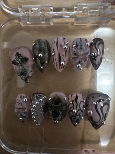Customer's Midnight Lily press-on nails featuring dark, intricate 3D floral designs and silver studs in a clear box.