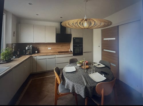 Customer's NEO teinté Chêne suspension au-dessus d'une table ronde recouverte d'une nappe à carreaux.