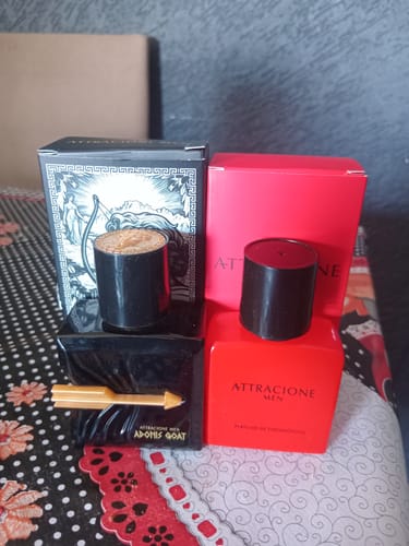 Customer's Attracione Men perfume bottles in red and black, displayed with their boxes on a patterned surface.