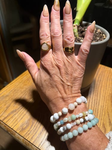 Customer's Sandbank Ring worn on a hand alongside stacked beaded bracelets and a gold textured ring.