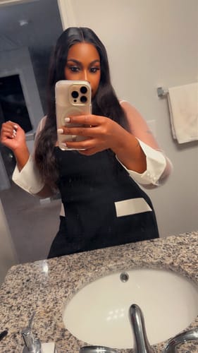 Reviewer in a bathroom mirror wearing the black Ponte Shirting Mini Dress with white contrast details.