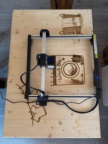 Customer's AtomStack Swift laser engraver creating designs on a large wooden surface.