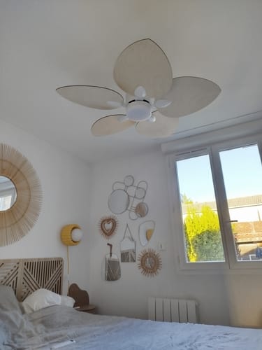 Reviewer's Dahlia ventilateur de plafond avec pales en bois clair, installé au plafond d'une chambre lumineuse.